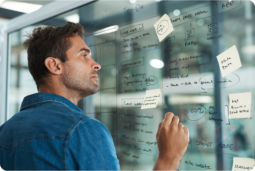 a man writing on a glass wall
